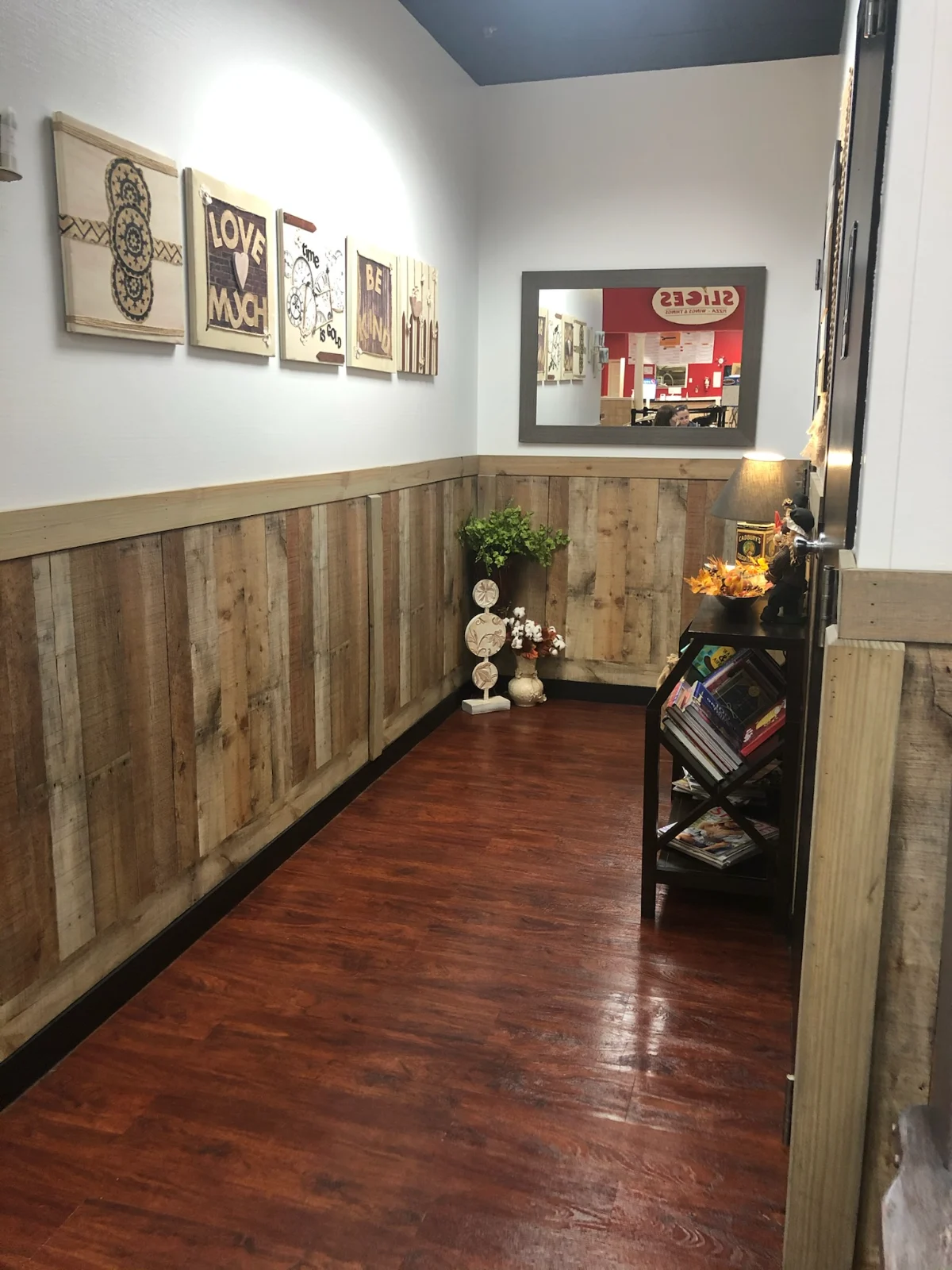 Commercial hallway with polished wood floors and dusted decor by Spotless Cleaning Services in Monroe, NC