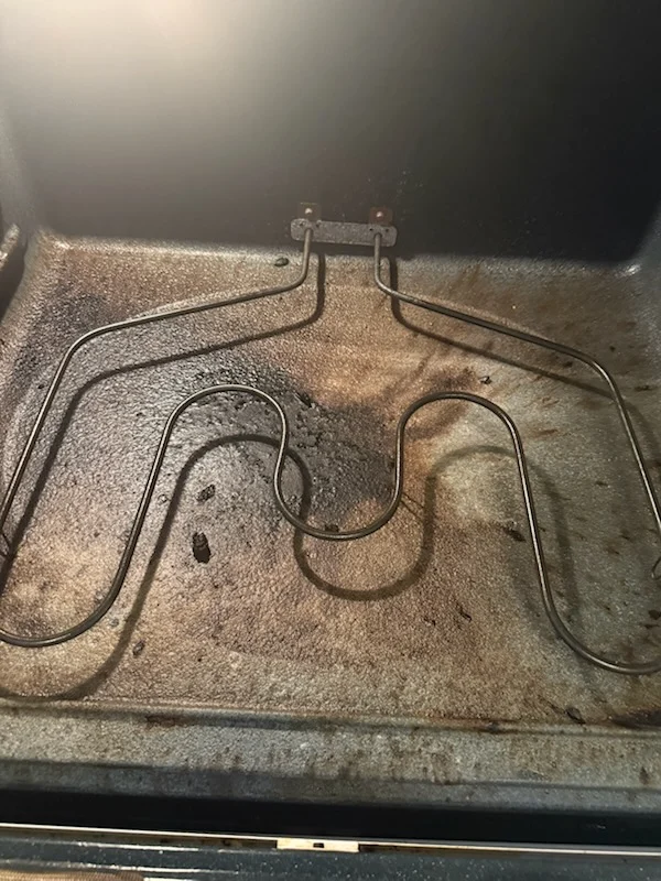 Oven interior covered in baked-on grease before interior cleaning by Spotless Cleaning Services in Monroe, NC